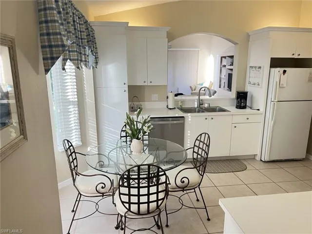 Dining area with light tile patterned floors and arched walkways