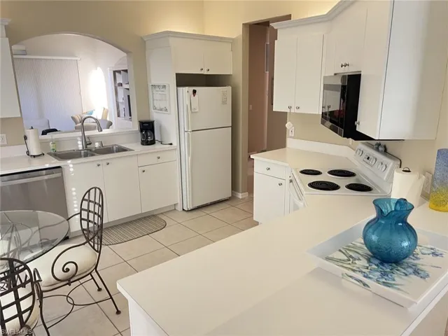 Kitchen featuring light tile patterned flooring, stainless steel appliances, and light countertops