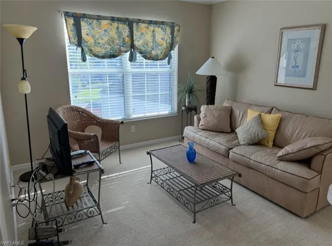 Den featuring carpet floors and baseboards