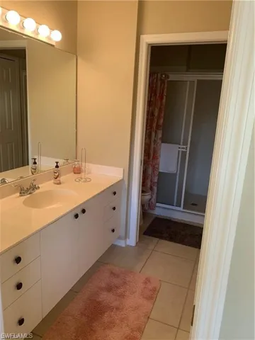 Master bath featuring vanity, light tile patterned floors, and a shower stall