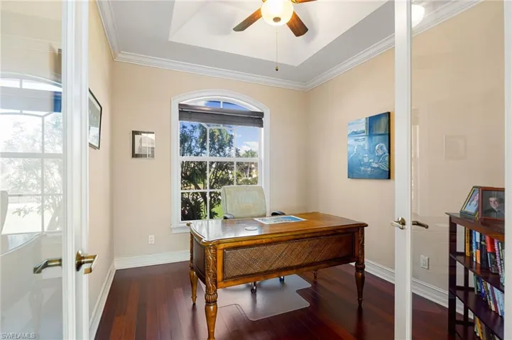 Office area with french doors, dark wood-style flooring, crown molding, and ceiling fan