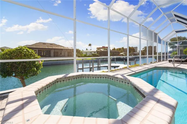 Integrated pool / spa with a sunroom, a water view, and a lanai