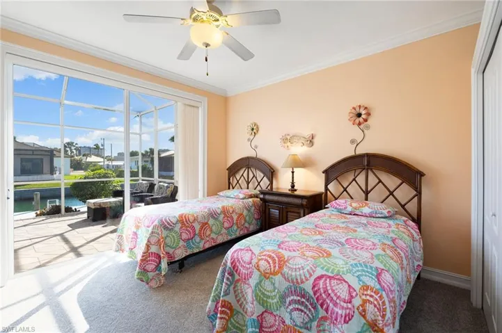 Bedroom with access to exterior, carpet, ornamental molding, and a ceiling fan