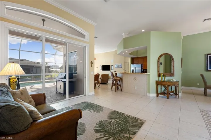 Living room with crown molding, light tile patterned floors, and recessed lighting