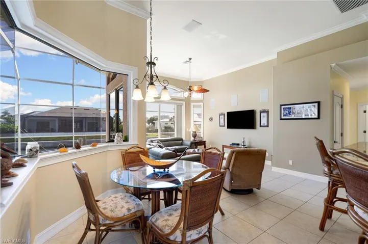 Dining area with crown molding and light tile patterned floors