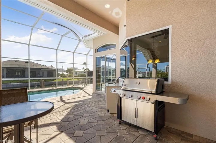 View of patio / terrace with a sunroom, an outdoor pool, a lanai, and area for grilling