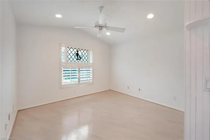 Den featuring ceiling fan, lofted ceiling, and light wood-type flooring