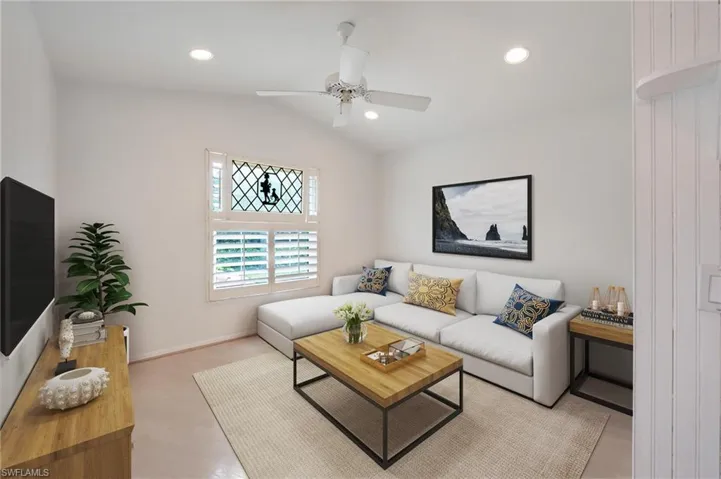 Den featuring lofted ceiling and ceiling fan