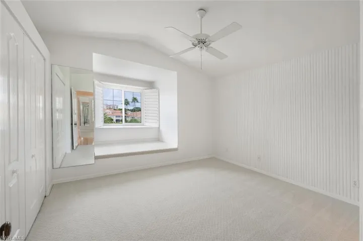 Carpeted Guest Bedroom with ceiling fan and lofted ceiling
