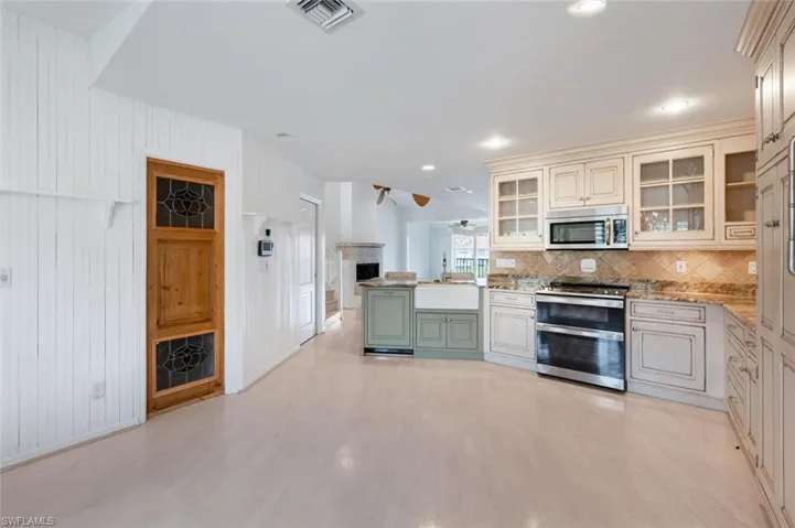 Kitchen featuring ceiling fan, light hardwood / wood-style flooring, stainless steel appliances, and tasteful backsplash