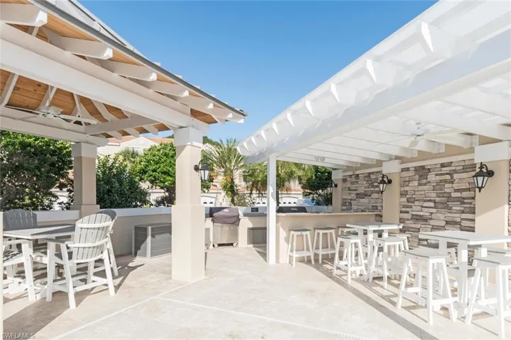 View of Grilling patio featuring an outdoor kitchen, exterior bar, ceiling fan, and a gazebo