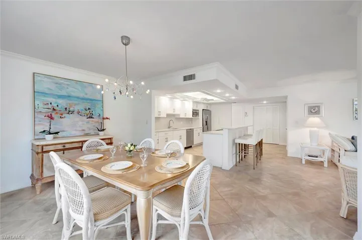 Dining space featuring a chandelier, ornamental molding, and recessed lighting