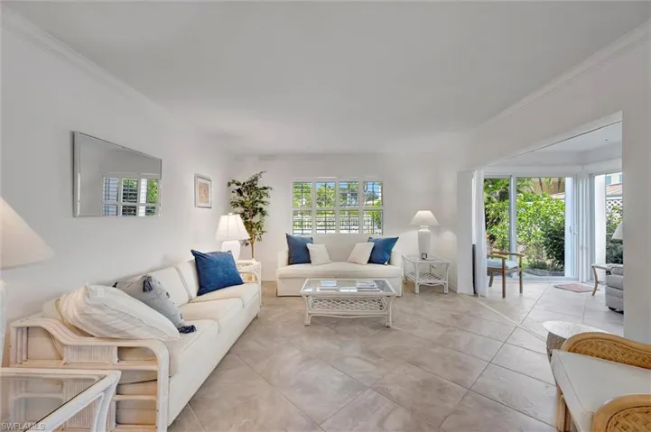 Living area with crown molding, plenty of natural light, and light tile patterned floors