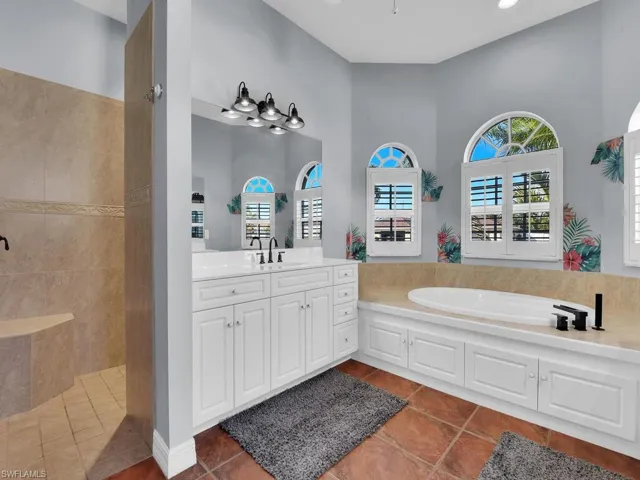 Bathroom featuring tile patterned floors, vanity, and shower with separate bathtub