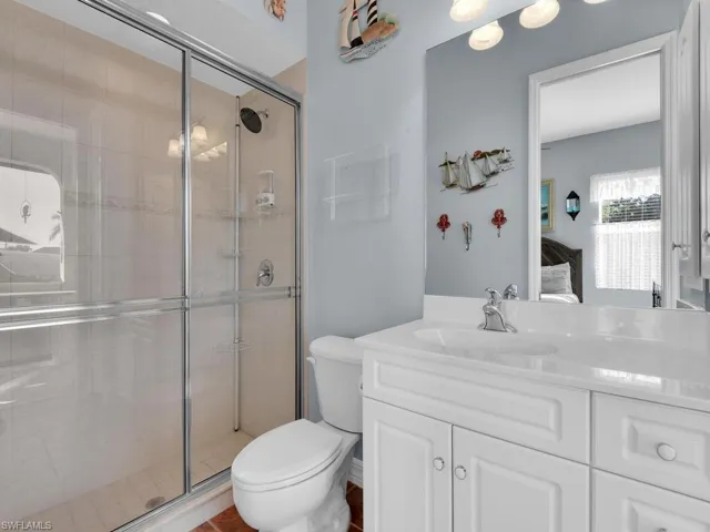 Bathroom featuring vanity, toilet, and an enclosed shower