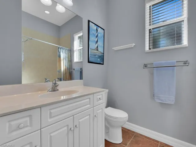 Bathroom featuring toilet, vanity, a shower with shower curtain, and tile patterned floors