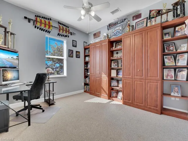 Office with light carpet and ceiling fan