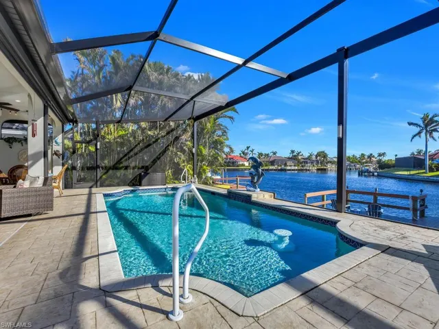 View of swimming pool with a lanai, a patio area, and a water view