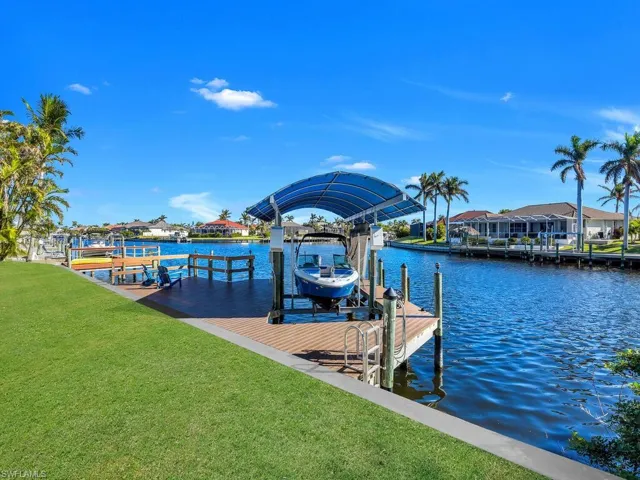 View of dock featuring a lawn and a water view