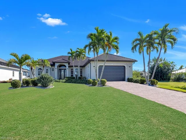 Mediterranean / spanish-style home featuring a garage and a front yard