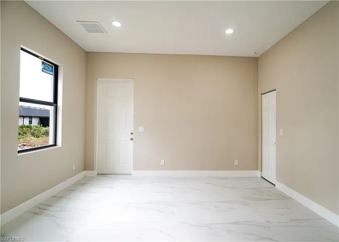 Unfurnished room with recessed lighting and light marble finish flooring