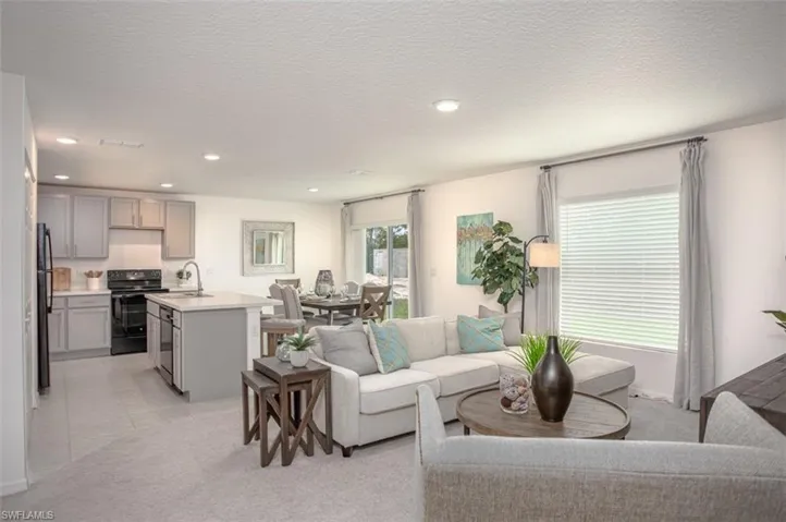 Carpeted living room featuring sink and a textured ceiling