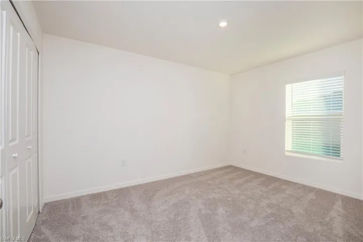 Unfurnished bedroom with light colored carpet and a closet