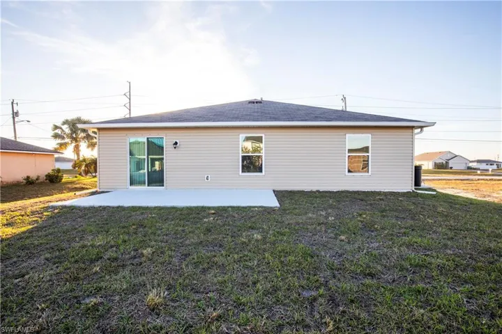 Rear view of house with a yard and a patio area