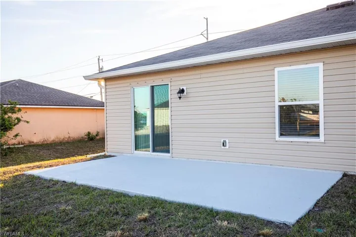 Rear view of property featuring a patio and a lawn