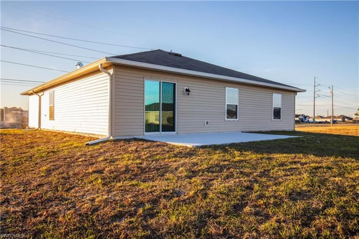 Back of house with a patio and a yard