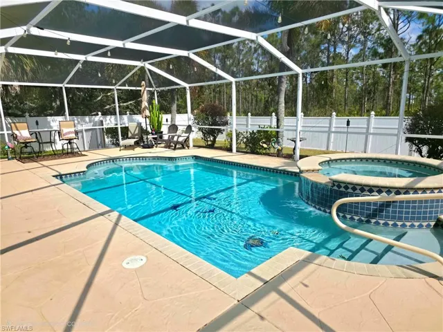Relaxing pool / spa with a fenced backyard, glass enclosure, a sunroom, and a patio