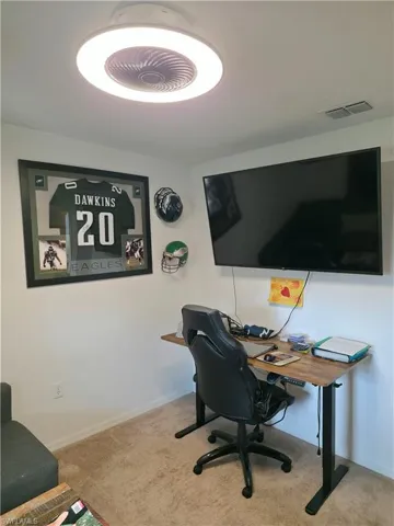 Home office featuring light carpet and baseboards
