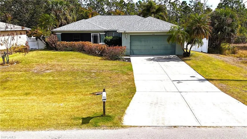 Ranch-style home with a front lawn, driveway, an attached garage, and a shingled roof