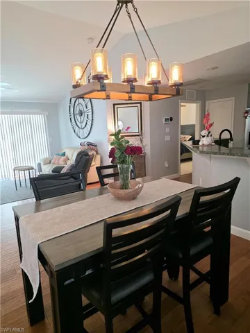 Dining room featuring dark wood-style floors and lofted ceiling