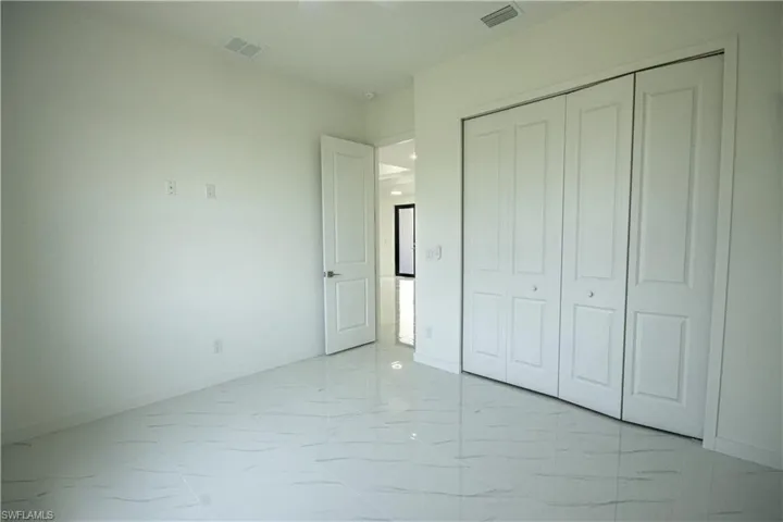 Unfurnished bedroom with visible vents, marble finish floor, and baseboards