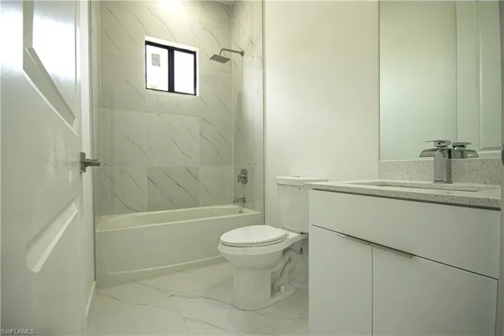 Full bathroom with vanity, toilet, marble finish floor, and bathtub / shower combination