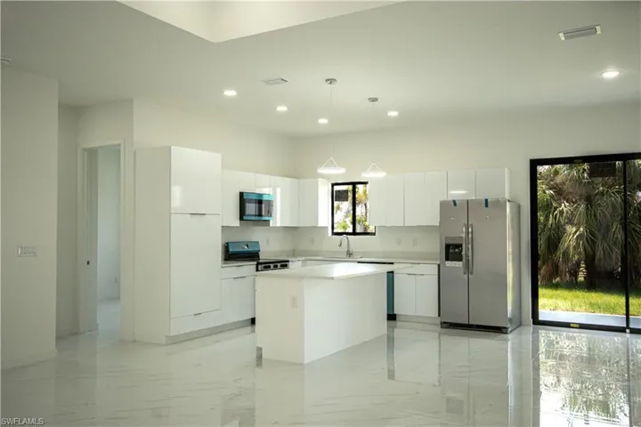 Kitchen featuring white cabinets, modern cabinets, a kitchen island, and stainless steel appliances