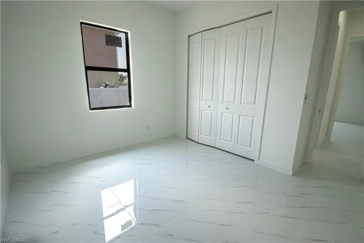 Unfurnished bedroom featuring baseboards, a closet, and marble finish floor