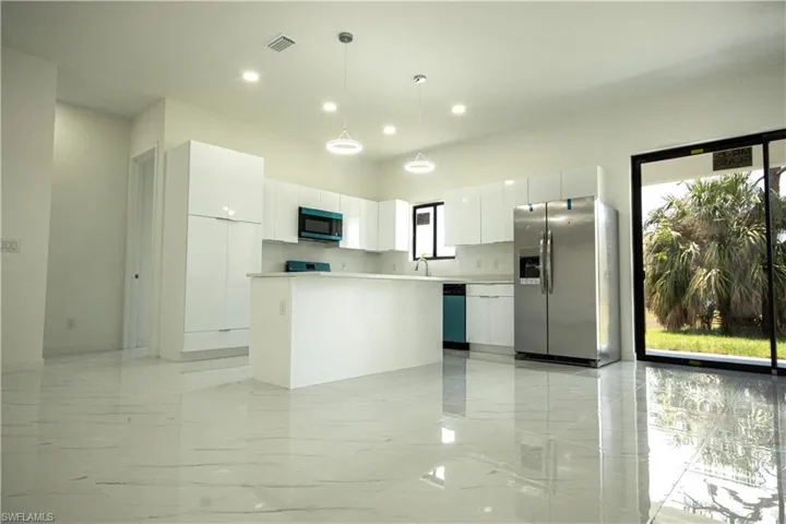 Kitchen with stainless steel fridge, marble finish floor, modern cabinets, and visible vents
