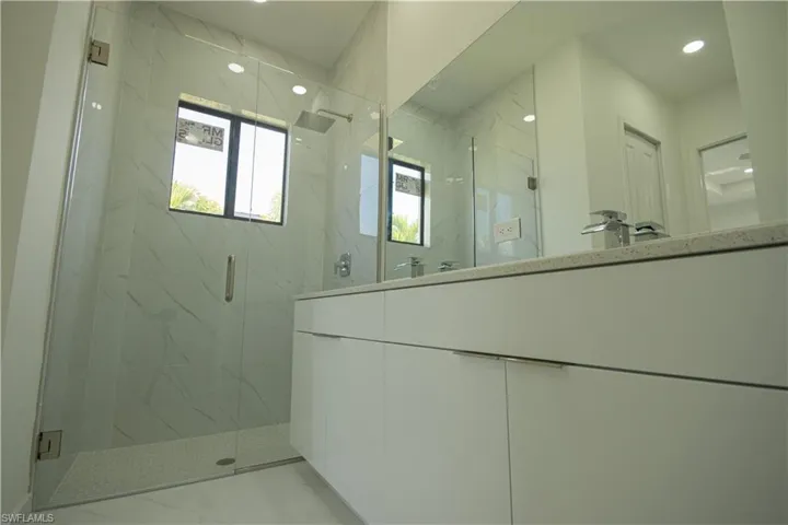 Bathroom with a marble finish shower, recessed lighting, and marble finish floor