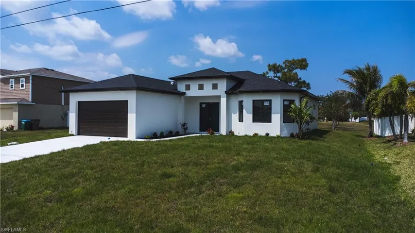 Prairie-style home with a garage, a front lawn, stucco siding, and concrete driveway