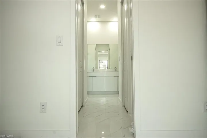 Hall featuring baseboards, recessed lighting, marble finish floor, and visible vents