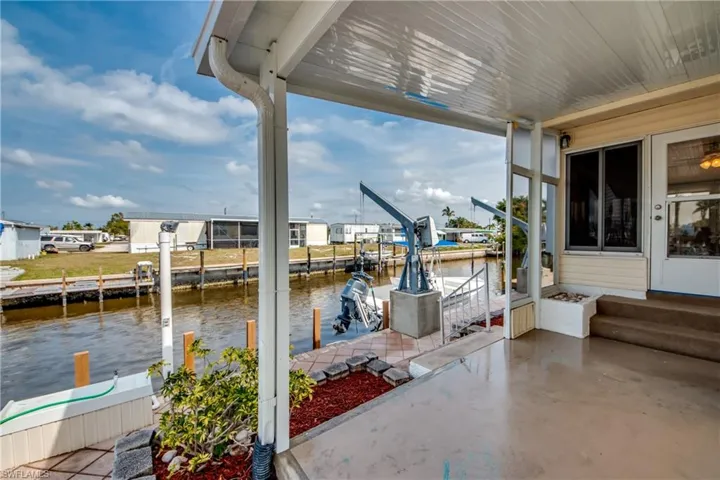 View of patio featuring a water view, boat lift, and a boat dock