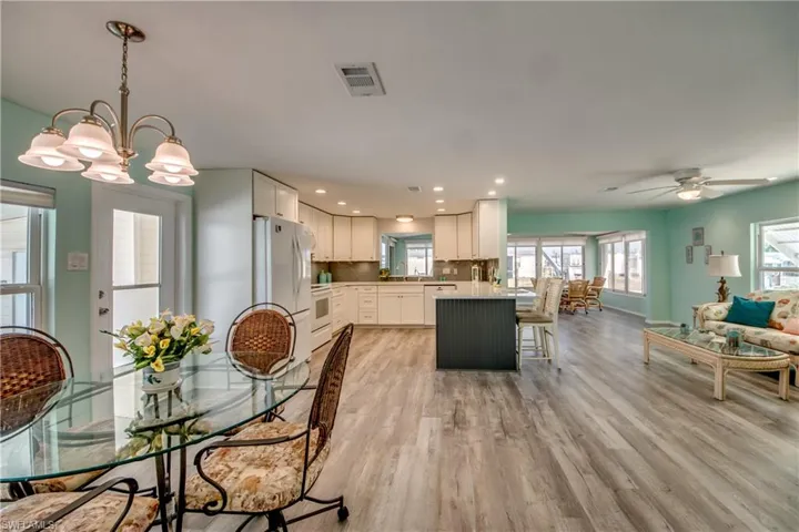 Dining area featuring light wood-style flooring, a ceiling fan, recessed lighting, and a chandelier