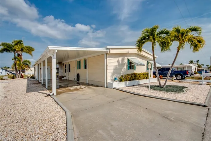 View of front of property with driveway and a carport