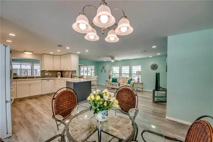 Dining space with light wood-style flooring, a chandelier, ceiling fan, and recessed lighting