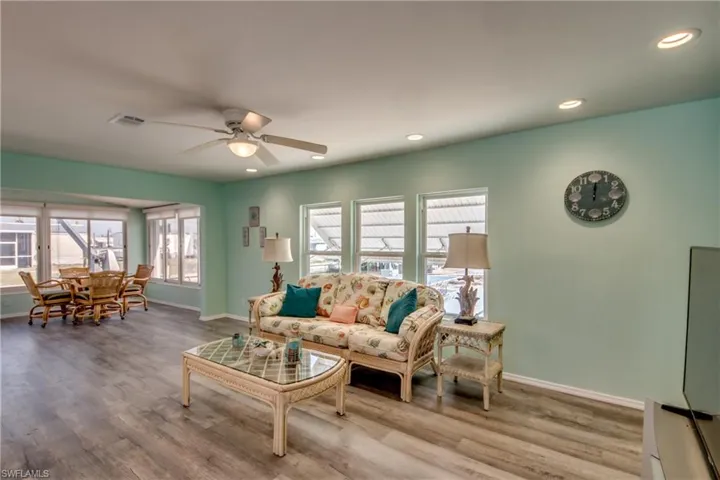 Living area with a ceiling fan, wood finished floors, and recessed lighting