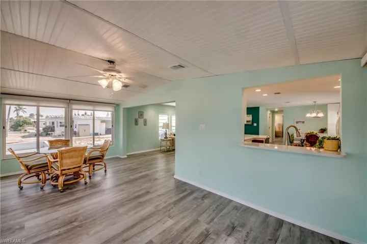 Dining space featuring vaulted ceiling, wood finished floors, a ceiling fan, a chandelier, and wood ceiling