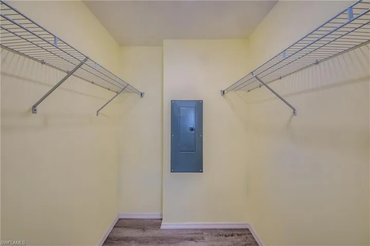 Spacious closet featuring electric panel and wood finished floors