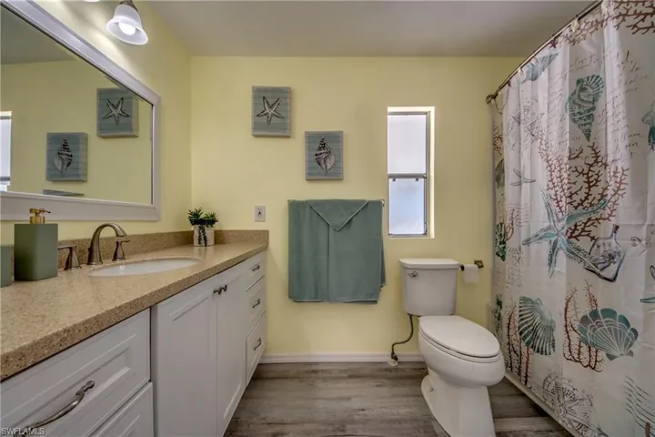 Full bathroom with wood finished floors and vanity